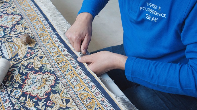 Teppichreparatur bei welcher die Fransenerneuerung in Handarbeit durchgeführt wird